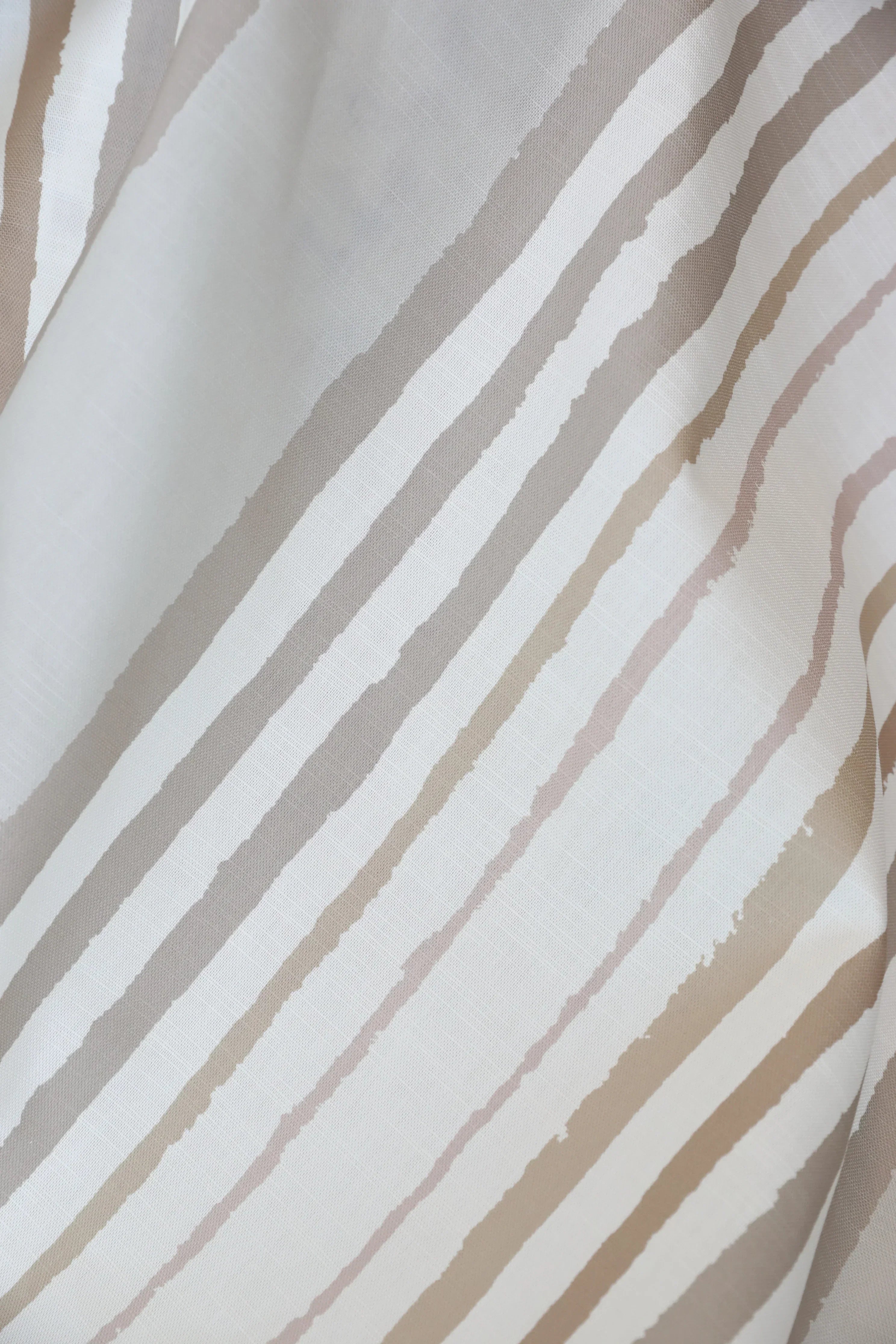 Brother Stripe in Neutrals Luxury Fabric by Truett Designs featuring an artistic stripe pattern in warm neutral tones. Handcrafted in England from sustainably printed luxury fabric, this designer fabric offers a refined foundation for layered interiors, bringing subtle structure, texture, and timeless elegance to sofas, beds, accent chairs, banquettes, and window seats. A favorite for interior designers, this versatile stripe pairs effortlessly with florals, botanicals, plaids, grasscloth wallcov