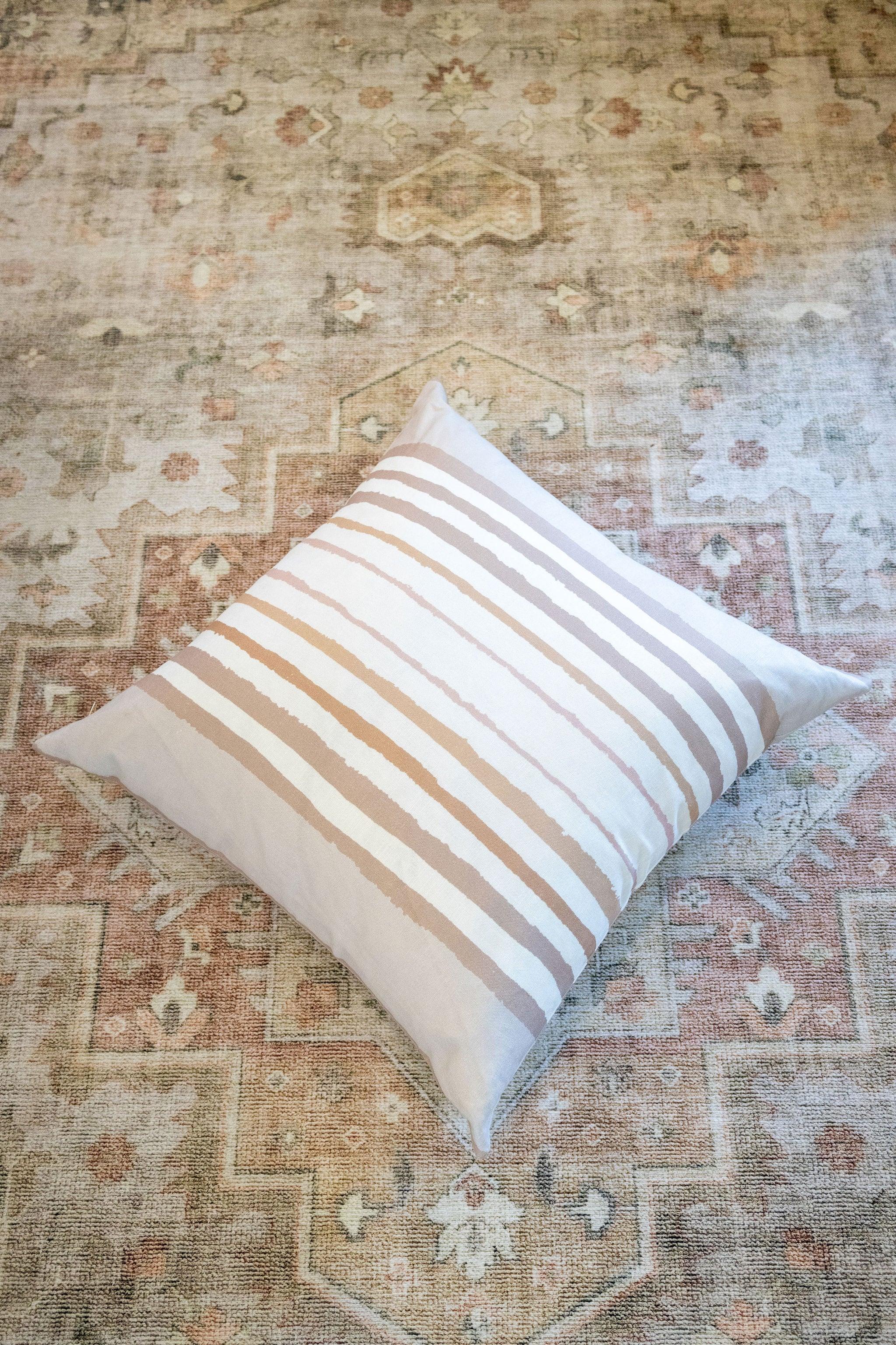 Brother Stripe in Neutrals Luxury Pillow by Truett Designs featuring an artistic stripe pattern in warm neutral tones. Handcrafted in England from sustainably printed luxury fabric, this designer decorative pillow adds structure, texture, and timeless elegance to sofas, beds, and accent chairs. A versatile favorite for interior designers, it pairs beautifully with florals, botanicals, grasscloth, natural linens, and tailored upholstery in luxury residential interiors.