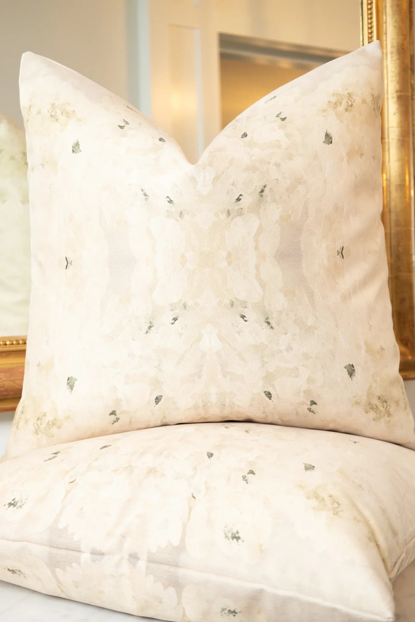 Centerpiece White Hydrangea luxury decorative pillow featuring a large-scale abstract floral pattern in layered white, cream, and deep olive green tones, handcrafted in England for luxury living rooms, designer-curated interiors, tailored upholstery, and thoughtfully layered homes.