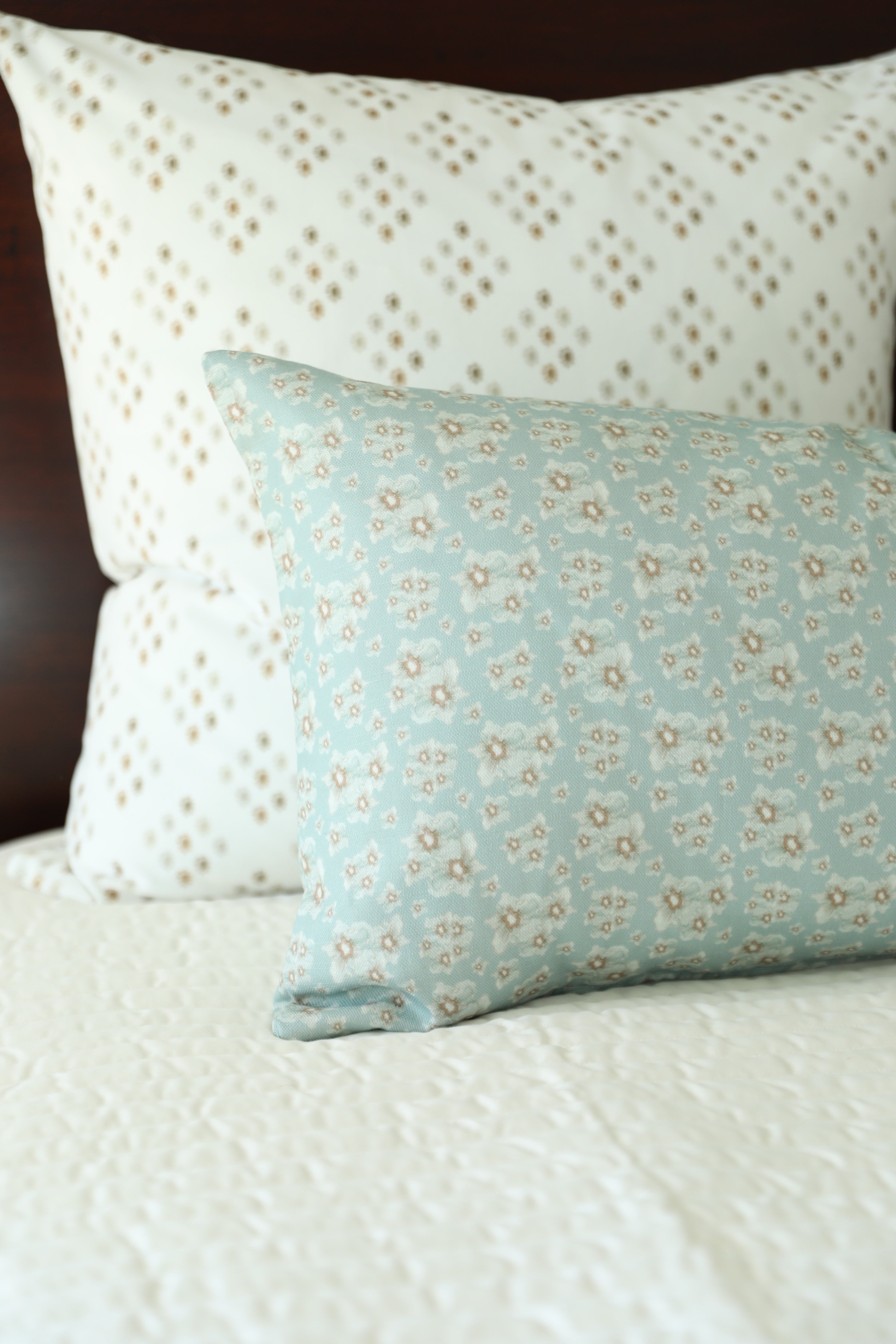 Luxury floral bolster pillow featuring a delicate cottage garden pattern with soft botanical detail, handcrafted in England for timeless and layered interiors.