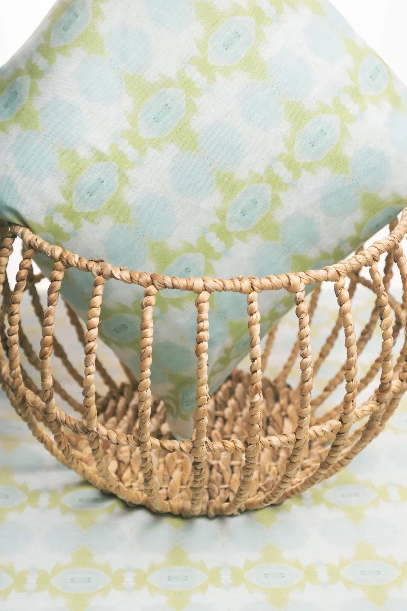 Luxury decorative pillow featuring an abstract small repeat pattern in chartreuse green and soft blue tones, styled for a layered modern traditional interior.