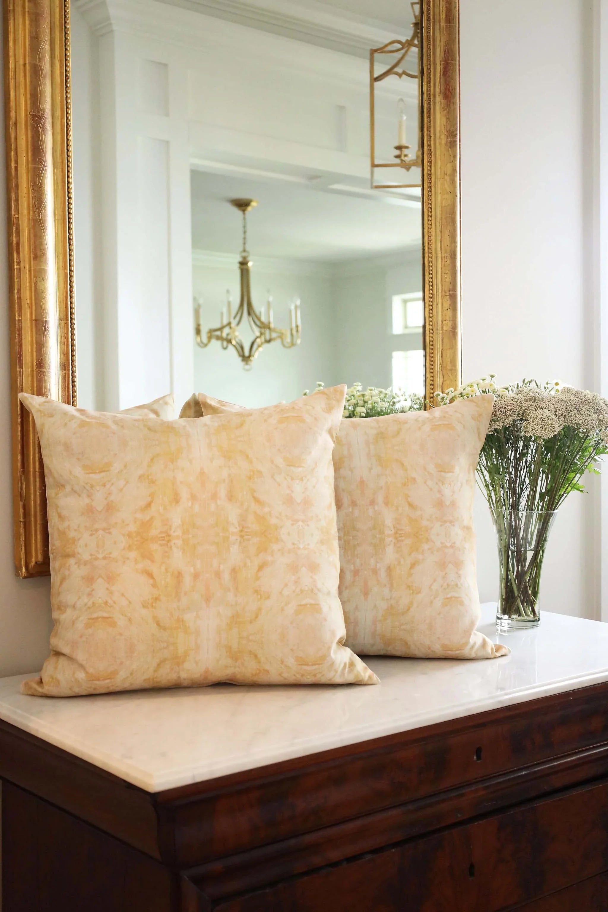 Luxury decorative pillow featuring an abstract topiary-inspired pattern in warm autumn gold and neutral tones, styled for a layered modern traditional interior.