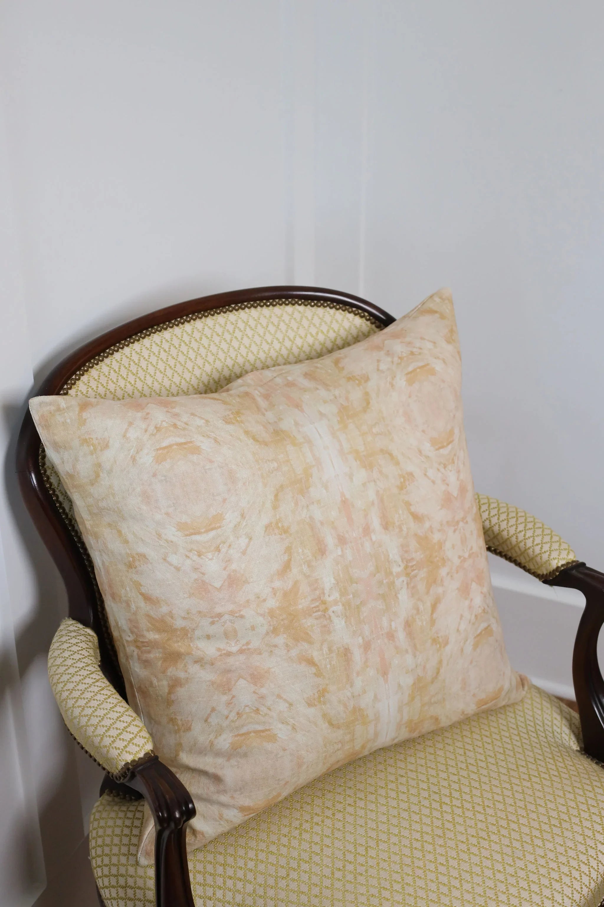 Luxury decorative pillow featuring an abstract topiary-inspired pattern in warm autumn gold and neutral tones, styled for a layered modern traditional interior.