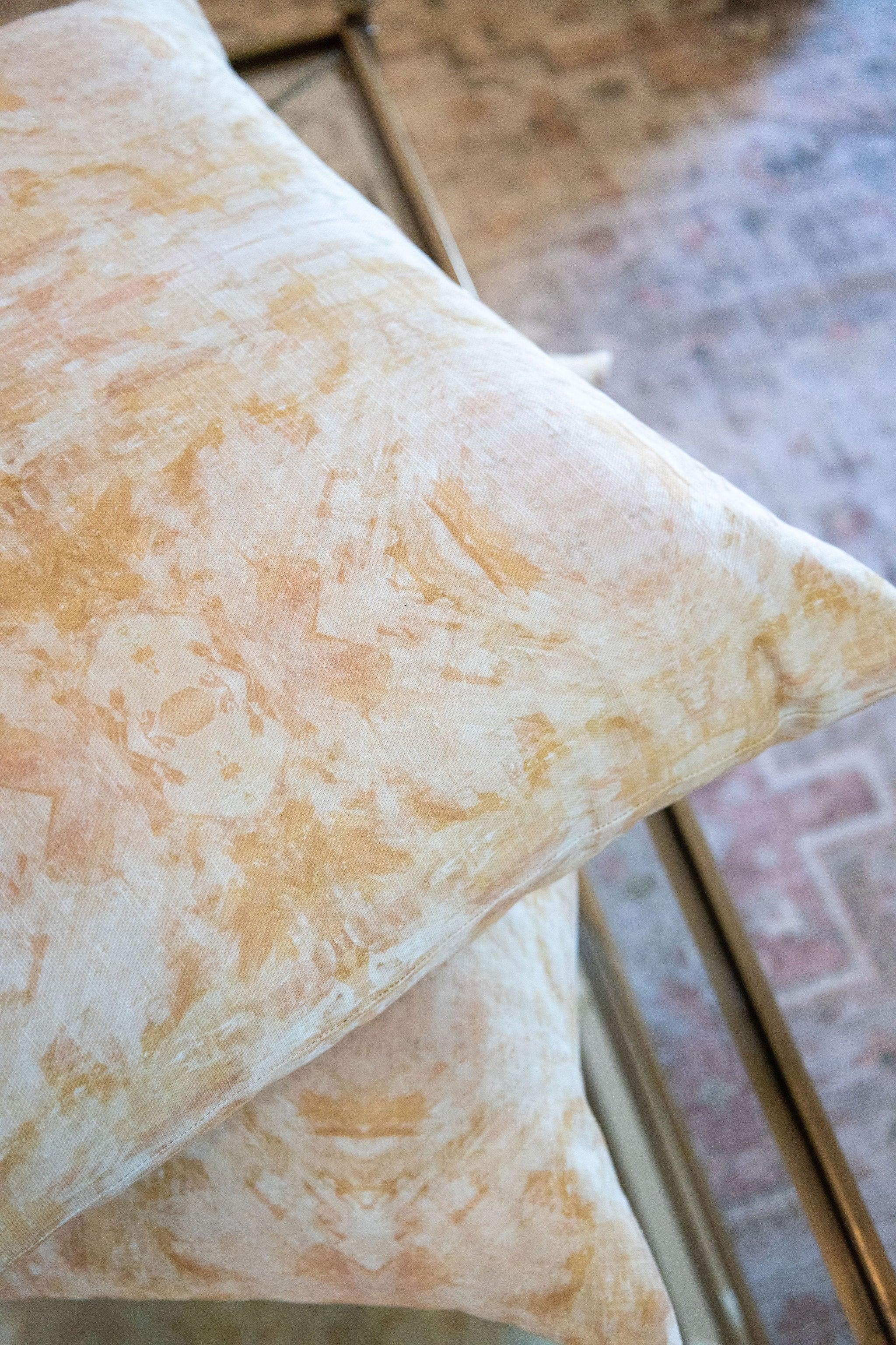 Luxury decorative pillow featuring an abstract topiary-inspired pattern in warm autumn gold and neutral tones, styled for a layered modern traditional interior.