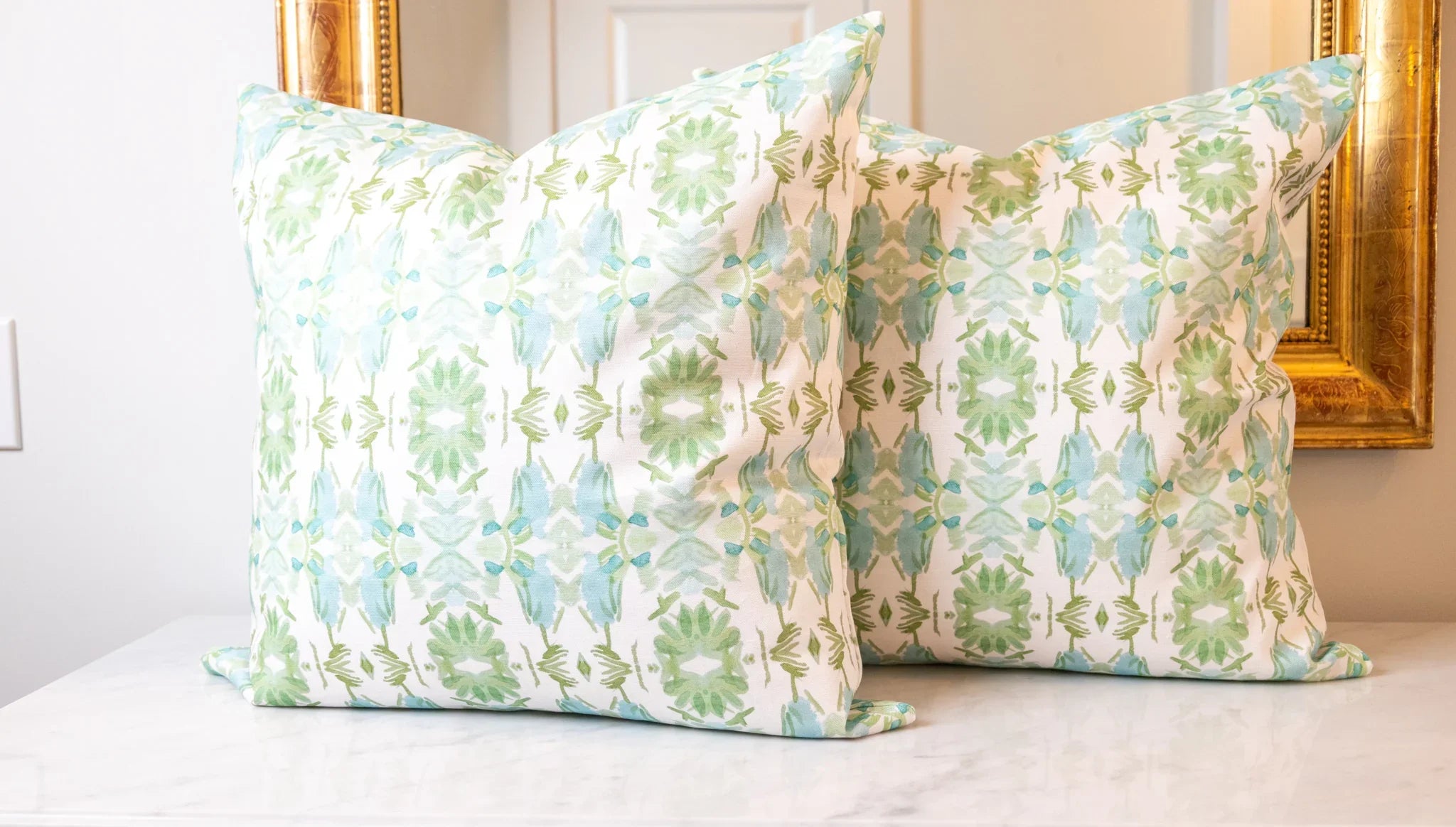 Luxury sage green and powder blue botanical pillow with large-scale floral pattern inspired by Alaska wildflowers, handcrafted in England and styled for contemporary and traditional interiors.